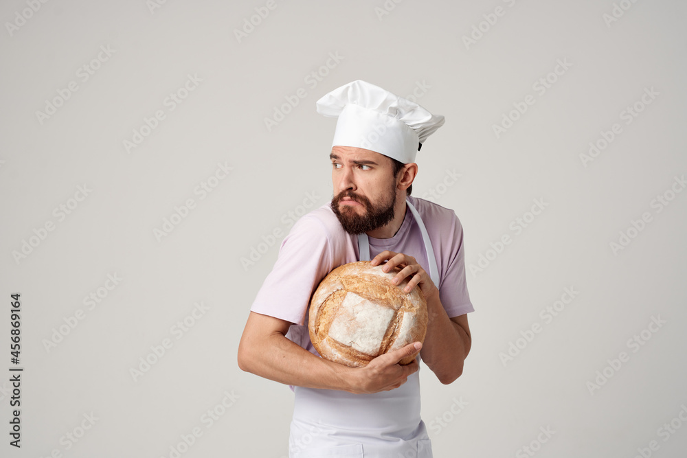 a man in a baker's uniform cooking bread a man in a baker's uniform cooking bread