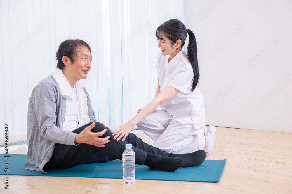 Fototapeta premium 足が痛い中高年男性と白衣の女性