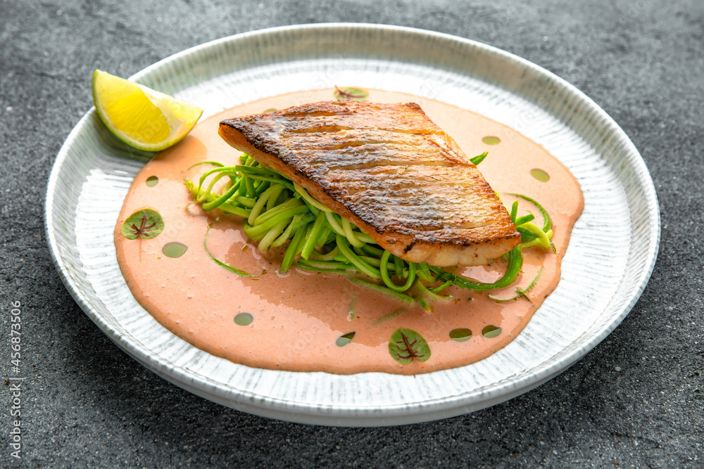 Fillet of sea bass or dorado with spinach paste. Ready menu for the restaurant. Neutral gray blue textured background Fillet of sea bass or dorado with spinach paste. Ready menu for the restaurant. Neutral gray blue textured background