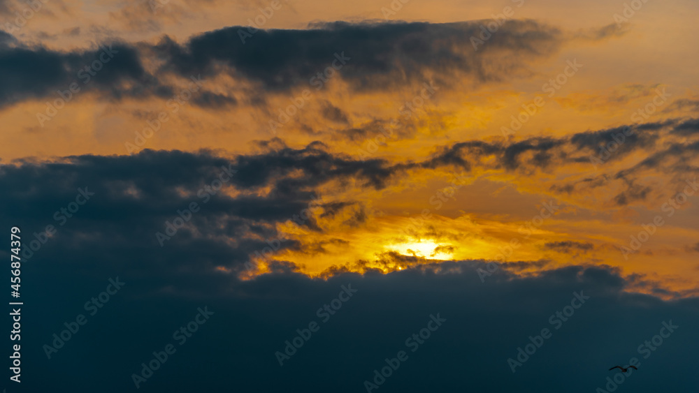 The sun at sunset among the clouds in the sky as a natural background.