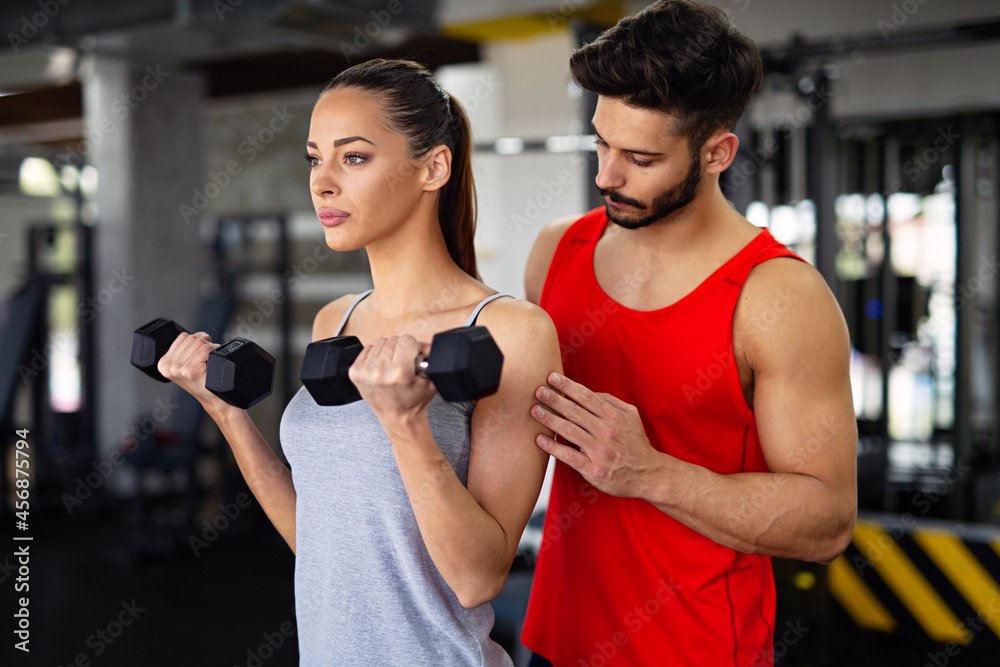 Personal trainer helping woman to working out in gym. Healthy lifestyle sport people concept Personal trainer helping woman to working out in gym. Healthy lifestyle sport people concept
