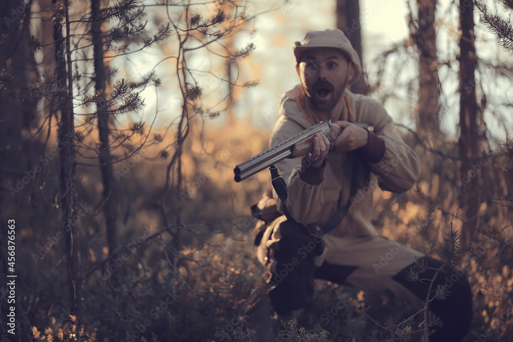 Naklejka premium hunting man / hunter with a gun hunting in the autumn forest, yellow trees landscape in the taiga