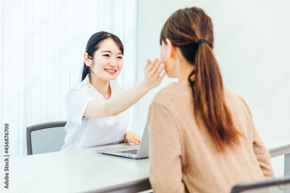 顔をチェックする白衣の女性
顔をチェックする白衣の女性