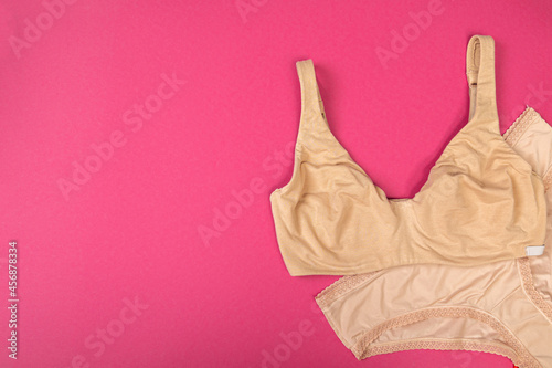 fashionable bra with panties on a pink background with copy space. Women's wardrobe, shopping concept.