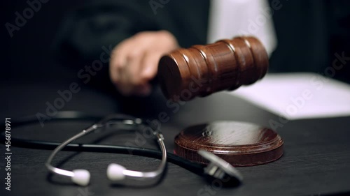 Judge striking gavel in health court, punishment for medical malpractice photo