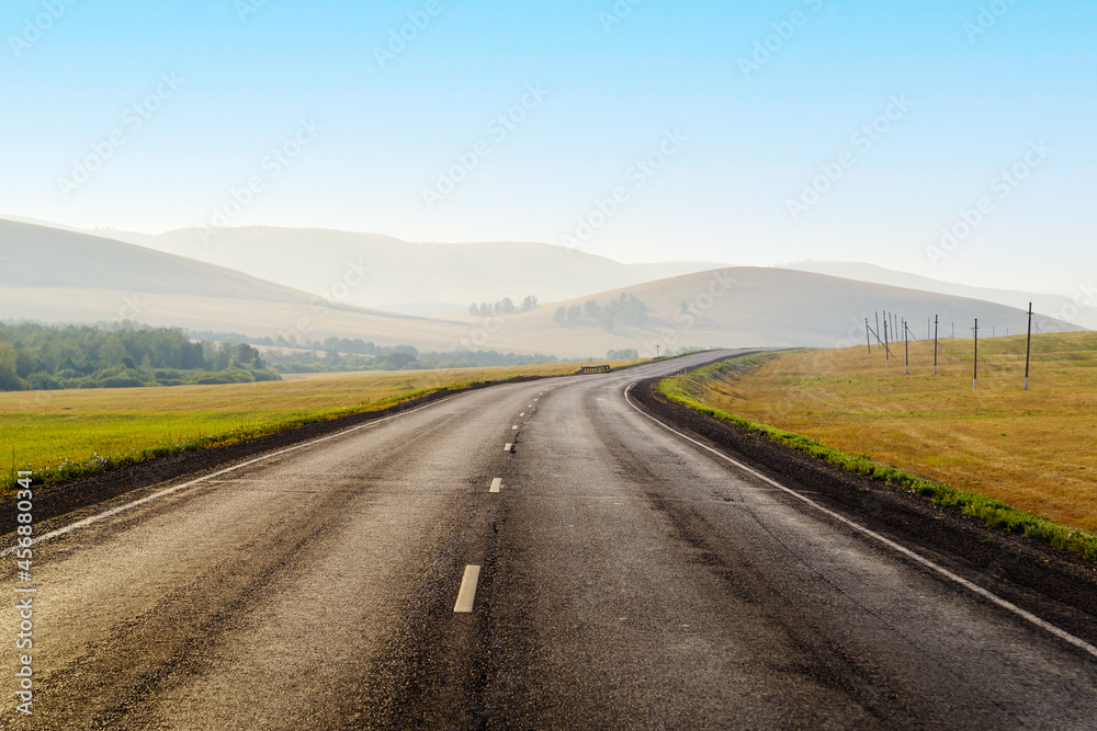 Highway stretching into the distance among the hills, in the early morning. The picture was taken in Russia, in Bashkiria