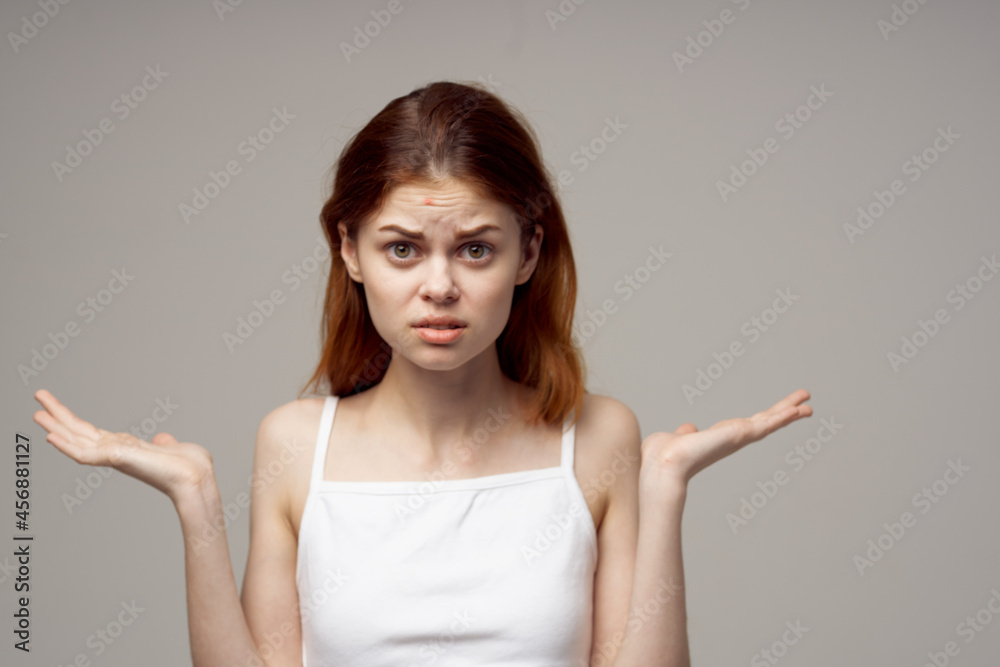 Fototapeta premium pretty woman in a white t-shirt pimples on the face light background
