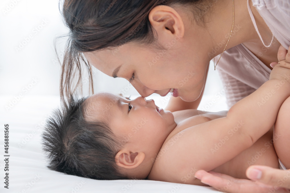 Happy loving family. asian mother lifting and playing with baby in the bedroom, enjoy tender family moment, motherhood. Love of a mother and baby. Family in the house. Lifestyle. Happy loving family. asian mother lifting and playing with baby in the bedroom, enjoy tender family moment, motherhood. Love of a mother and baby. Family in the house. Lifestyle.
