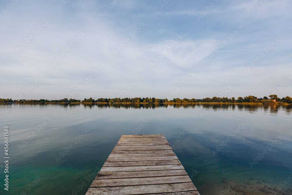Landscape photography, view of a large lake with blue water with wooden masonry at sunset