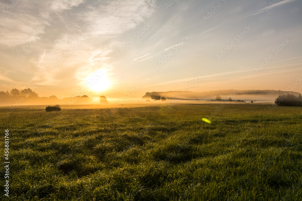 Beautiful sunset in rural landscape with sun rays shining through the morning fog Beautiful sunset in rural landscape with sun rays shining through the morning fog