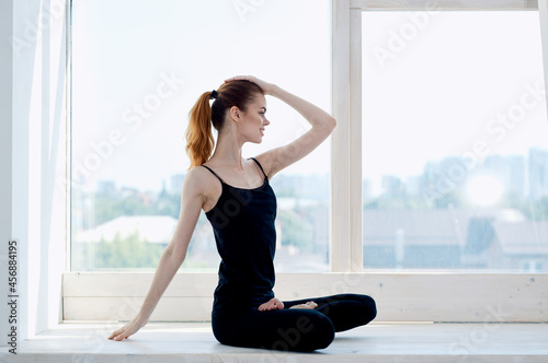 sportive woman meditates near window yoga asana lifestyle