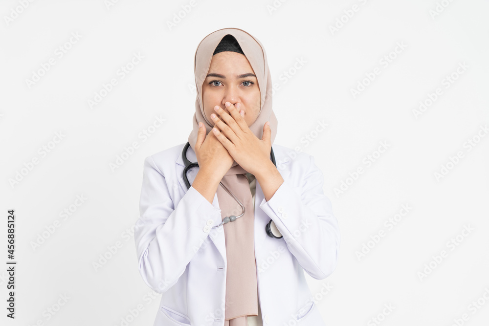 female doctor wearing white suit uniform covering her mouth with both hands female doctor wearing white suit uniform covering her mouth with both hands