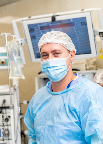 Portrait of surgeon wearing surgical gloves and scrubs in operation theater. Doctor in scrubs and medical mask in hospital operating room