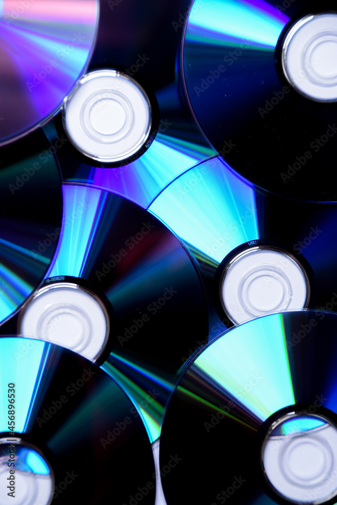 Closeup detail of multiple CD and DVD discs, software, music and film format. Closeup detail of multiple CD and DVD discs, software, music and film format.
