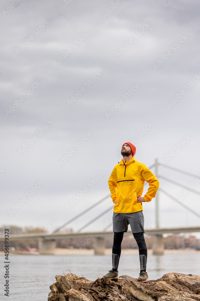 Man relaxing by the river after jogging