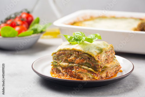 Lasagna - Lasagne alla bolognese with spinach in the dough, ragu - meat sauce, bechamel and parmesan cheese. Italian food. Horizontal image.