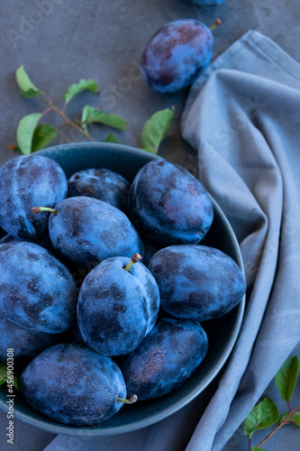 Fresh raw blue plums on the table, monochromatic color image