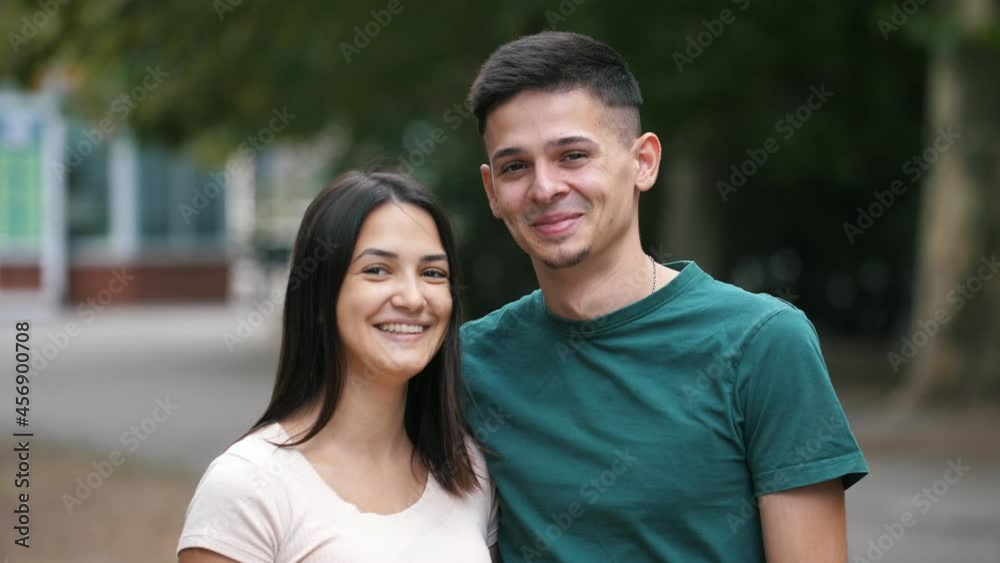 Good-humored young family standing, hugging and laughing happily in summer Good-humored young family standing, hugging and laughing happily in summer
