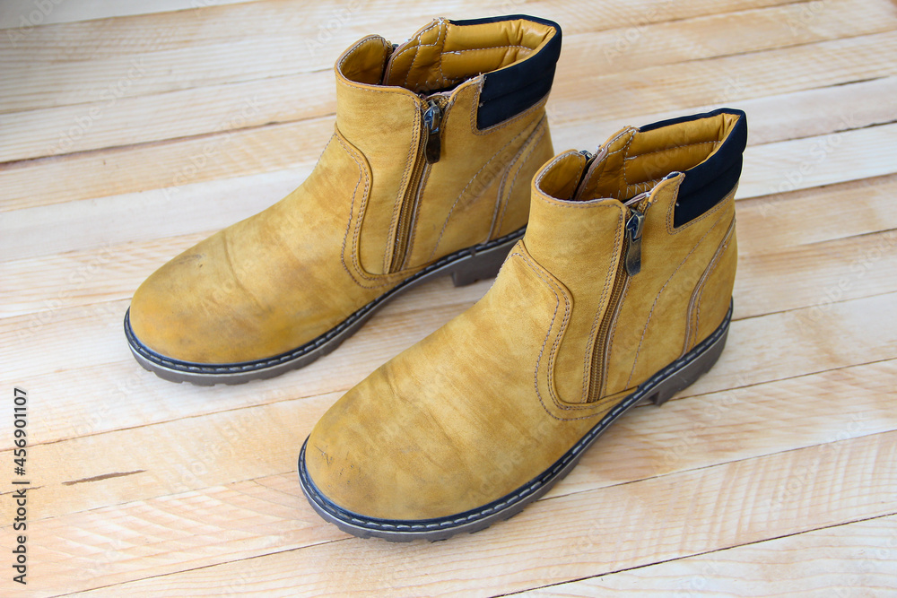 Shabby yellow shoes on wooden background