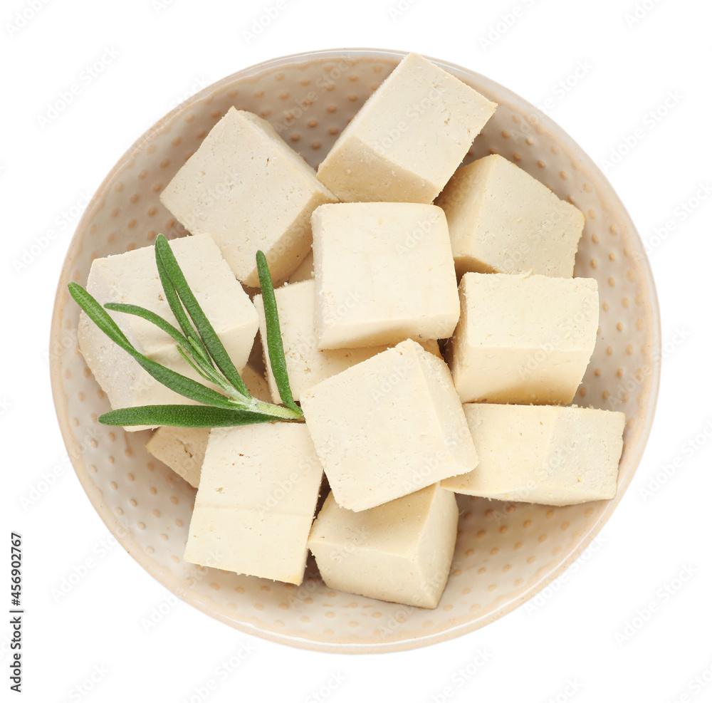 Bowl with delicious raw tofu pieces and rosemary on white background, top view