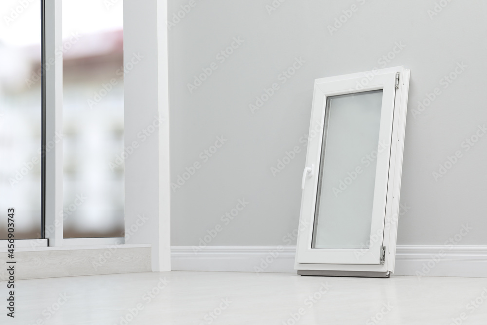 Modern single casement window near light grey wall indoors, space for text Modern single casement window near light grey wall indoors, space for text
