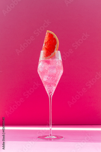 Cocktail in a glass with colored backgrounds and shadows on the wall