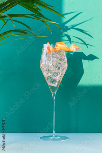 Cocktail in a glass with colored backgrounds and shadows on the wall