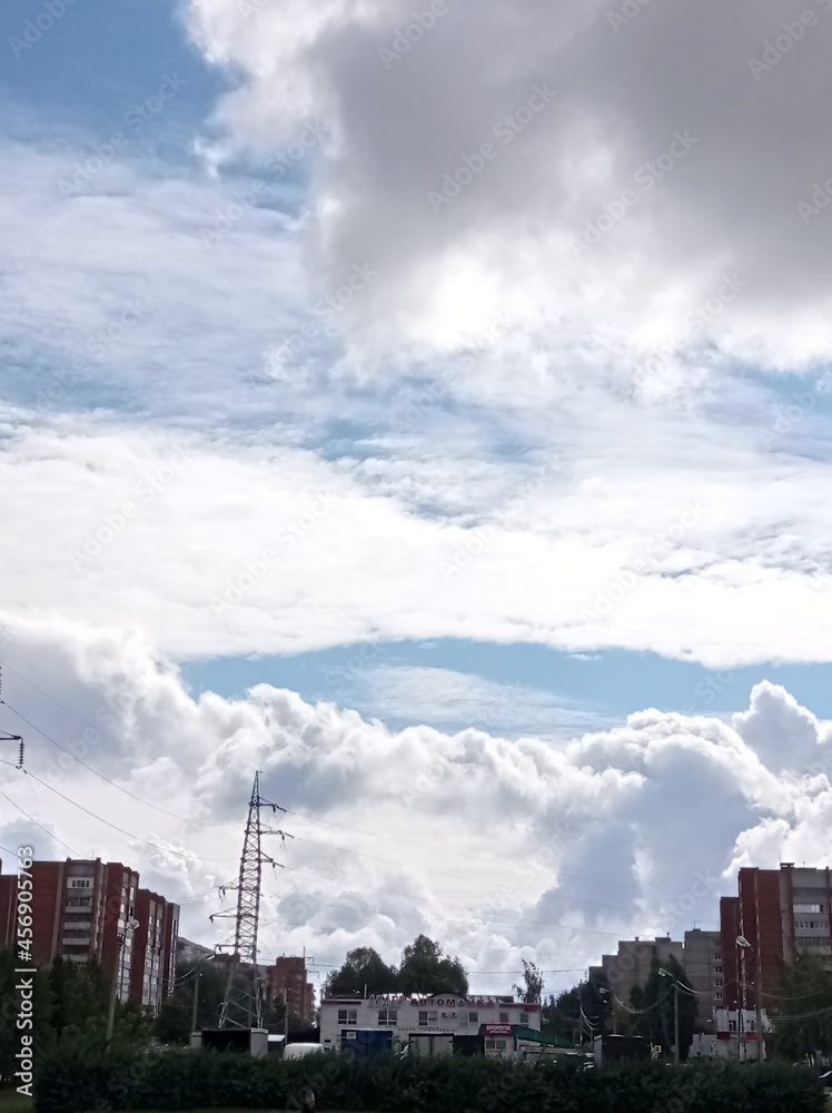 Huge white clouds on top of multi-storey buildings