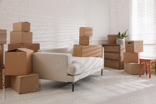 Furniture and cardboard boxes with packed stuff in room. Moving day © New Africa