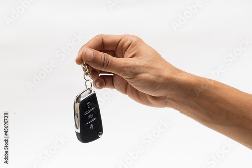 hand holding car remote isolated on white background 