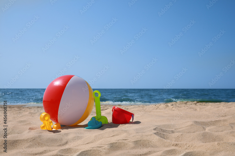 Obraz premium Many different sand toys and beach ball near sea, space for text