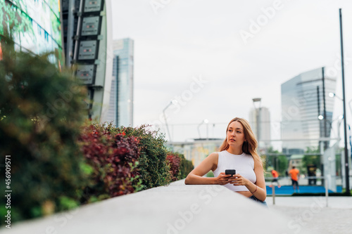 Young caucasian woman using smartphone looking over positive and trustful in future