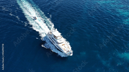 Aerial drone photo of luxury yacht cruising in deep blue sea near island of Mykonos, Cyclades, Greece © aerial-drone
