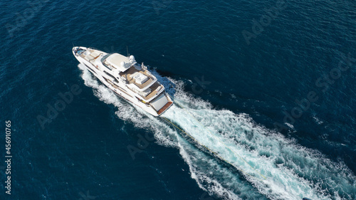 Aerial drone photo of luxury yacht cruising in deep blue sea near island of Mykonos, Cyclades, Greece