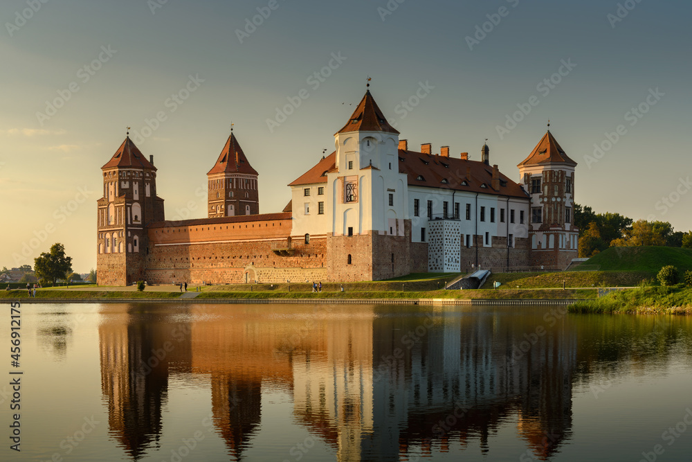 Mir Castle, Belarus. Scenic panoramic view of the complex across the pond with reflections on the water in the evening twilight