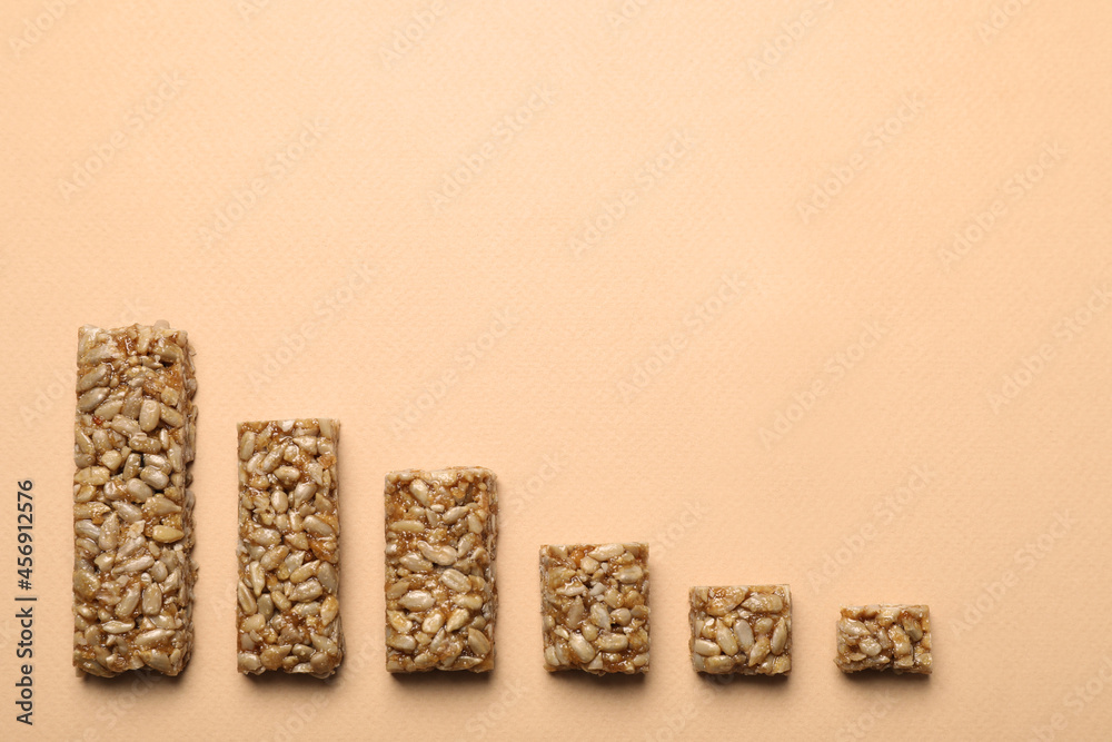 Pieces of delicious kozinaki bars on beige background, flat lay. Space for text Pieces of delicious kozinaki bars on beige background, flat lay. Space for text