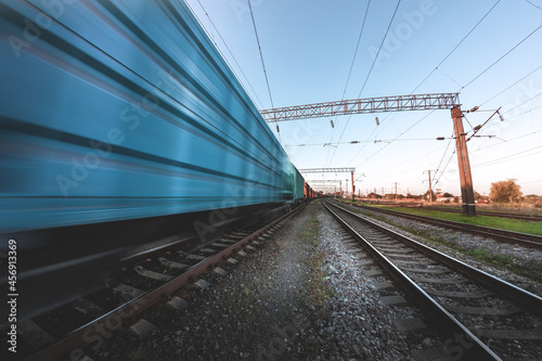Freight train in motion with blur effect at sunset. Cargo transportation by rail