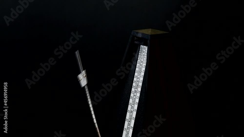 Close-up metronome at 72 BPM against black background