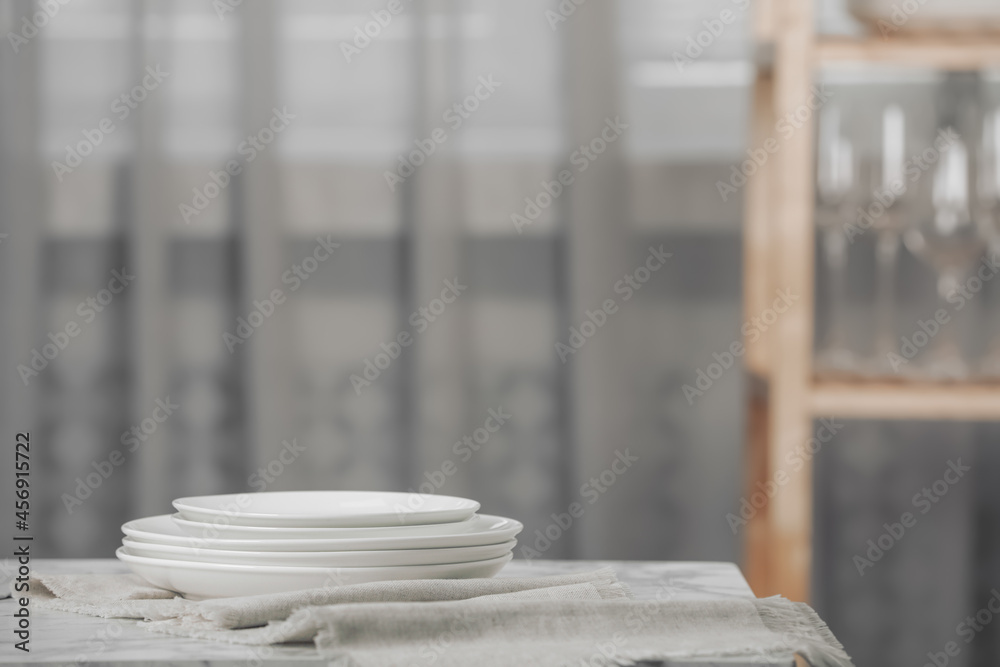 Stacked clean dishes and towel on white marble table indoors Stacked clean dishes and towel on white marble table indoors