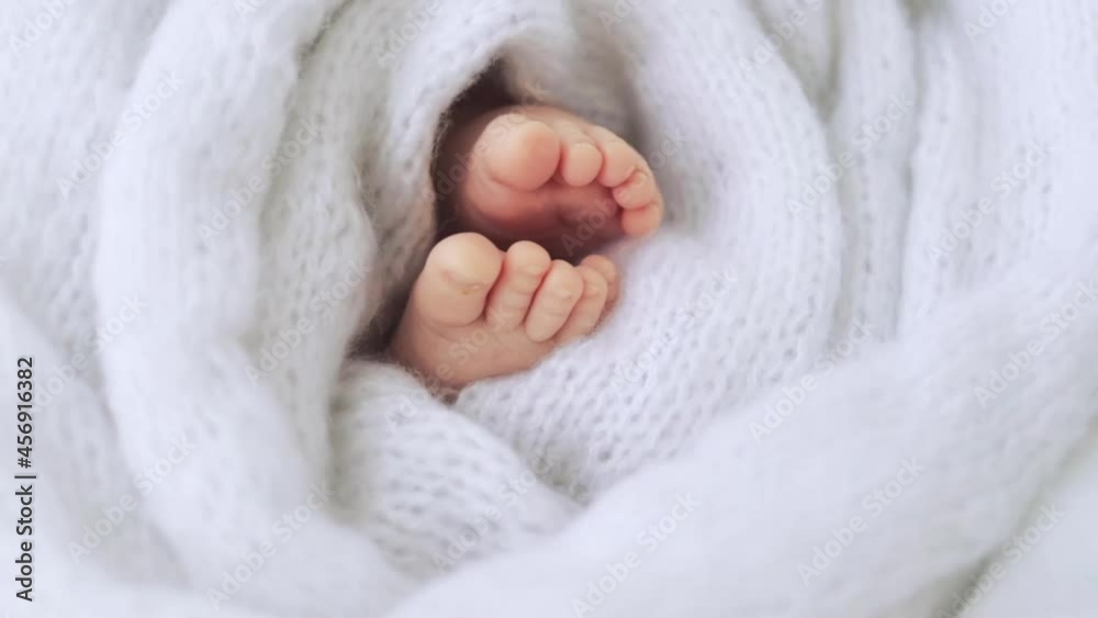 legs of a newborn baby close-up in white fabric legs of a newborn baby close-up in white fabric