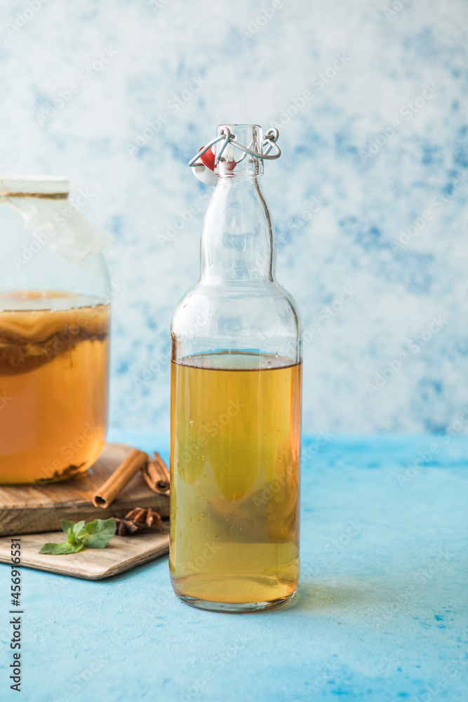 Raw fermented homemade alcoholic or non alcogolic kombucha superfood. Ice tea with healthy natural probiotic in glass with mint on blue background Raw fermented homemade alcoholic or non alcogolic kombucha superfood. Ice tea with healthy natural probiotic in glass with mint on blue background