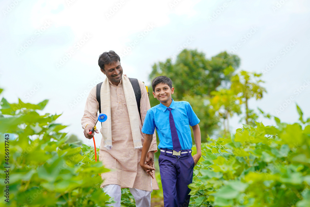 Young indian farmer with his son at green agriculture field. - obrazy, fototapety, plakaty 