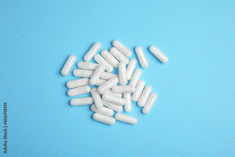 Pile of amino acid pills on light blue background, flat lay Pile of amino acid pills on light blue background, flat lay