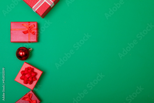 Composition of presents with bauble and copy space on green background