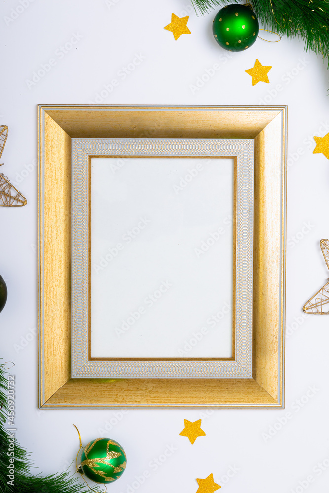 Fototapeta premium Composition of frame with copy space and fir tree branches with baubles on white background