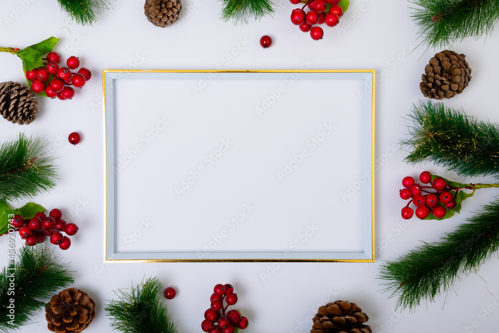 Fototapeta premium Composition of frame with copy space and fir tree branches with pine cones on white background