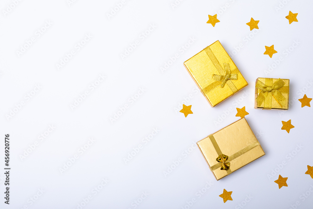 Obraz premium Composition of gold presents with stars and copy space on white background