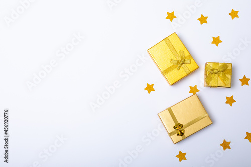 Composition of gold presents with stars and copy space on white background