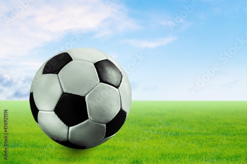 Classic Football ball lies in the green grass at the stadium © BillionPhotos.com