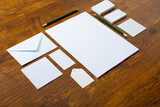 Composition of white cards and envelopes with pencils on wooden background
